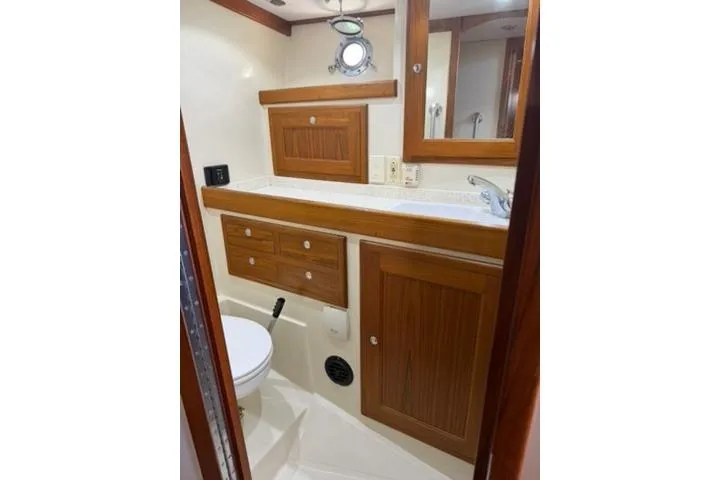 2001 Nordhavn 40 - Wayward Snug - Head with toilet, vanity, mirror, and teak cabinetry
