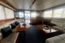 2016 Nordhavn 60 - CHOICES - Salon overview looking aft with L-shaped settee, lounge chairs, and entertainment center