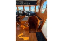 2016 Nordhavn 52 - Aleoli - Pilothouse helm console with steering wheel, nav pod, and companionway hatch to lower deck