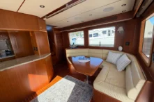 2016 Nordhavn 52 - Aleoli - Salon dinette with leather settee, teak table, and galley counter with granite top