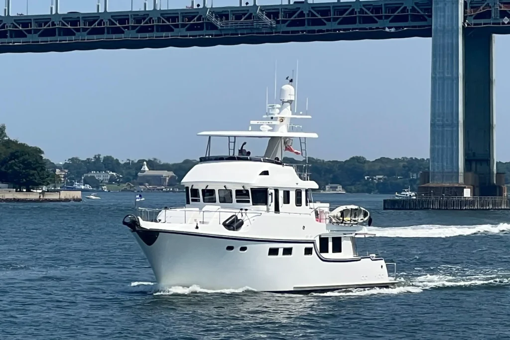 2011 Nordhavn 60 Trawler ONYXIA cruising under a bridge on a sunny day