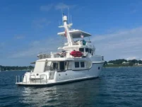 2011 Nordhavn 60 Trawler ONYXIA anchored on calm water under a clear blue sky