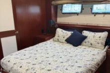 2011 Nordhavn 60 Trawler ONYXIA stateroom with bedding and wood accents