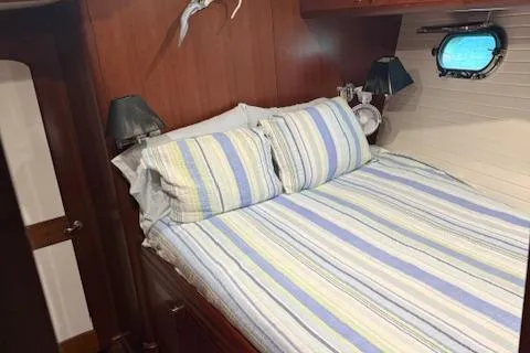 2011 Nordhavn 60 Trawler ONYXIA guest cabin with striped bedding and porthole window