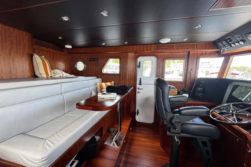 2025 Nordhavn 475 Listo pilothouse interior with helm station, captain's chair, and lounge seating