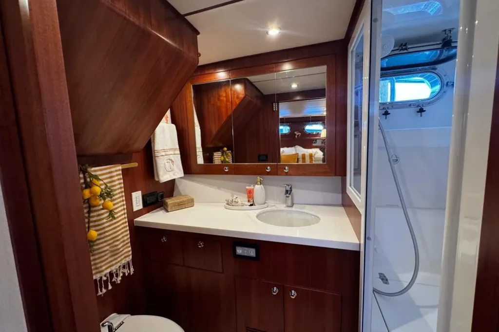 2025 Nordhavn 475 Listo master en-suite head with Corian vanity, mirrored cabinet, and separate glass shower