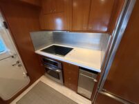 N6416 - AEGEAN MIST - close-up of GE Profile stainless steel built-in wall oven with digital touch controls set into warm teak cabinetry