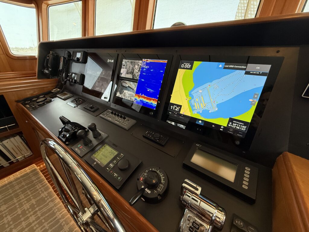 N6416 - AEGEAN MIST - pilothouse wide view from aft showing two black leather captain's chairs, full helm station with chartplotters, and orchid flower arrangement