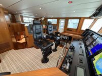 N6416 - AEGEAN MIST - forward stateroom showing raised berth with light grey bedding and pillows, curved gray leather sofa below, and porthole window