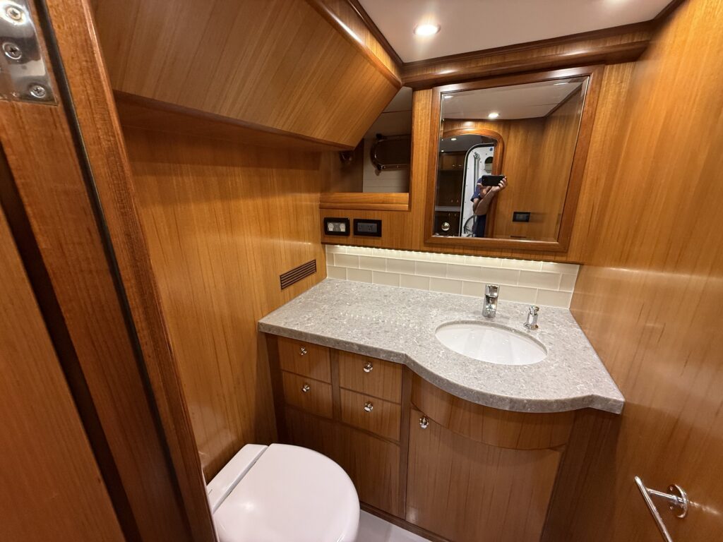 N6416 - AEGEAN MIST - crew or guest head bathroom with grey granite countertop, oval undermount sink, chrome fixtures, framed mirror, and toilet
