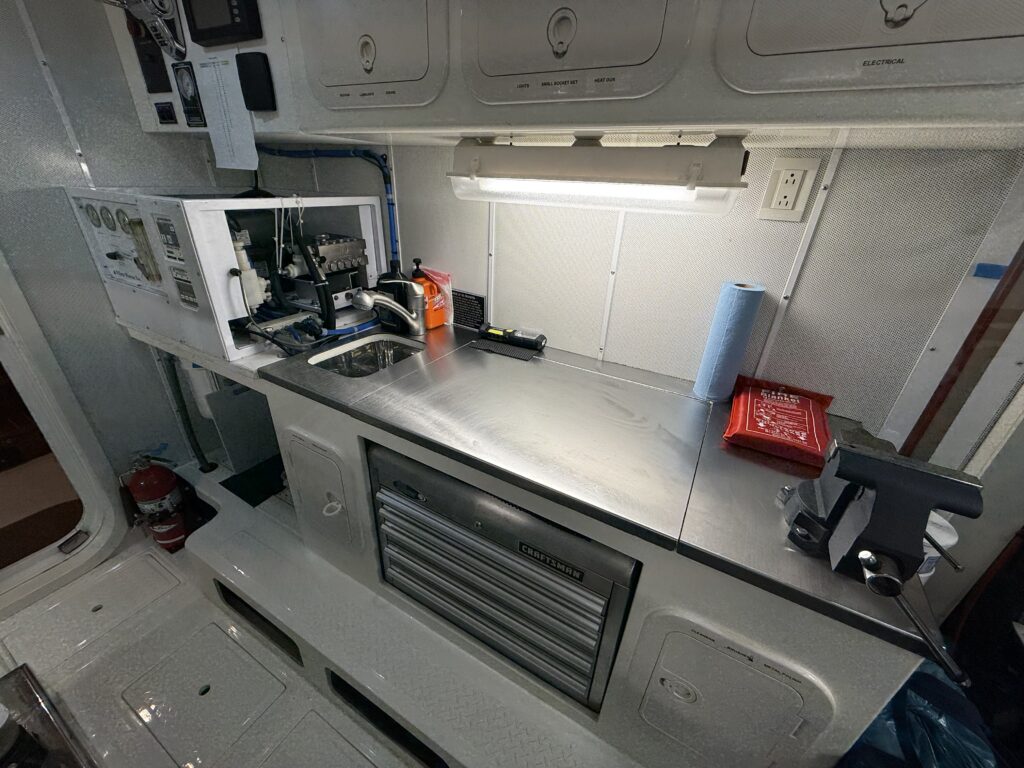 N6416 - AEGEAN MIST - engine room workbench area with stainless steel countertop, Craftsman tool drawers, fire blanket, and open electrical panel
