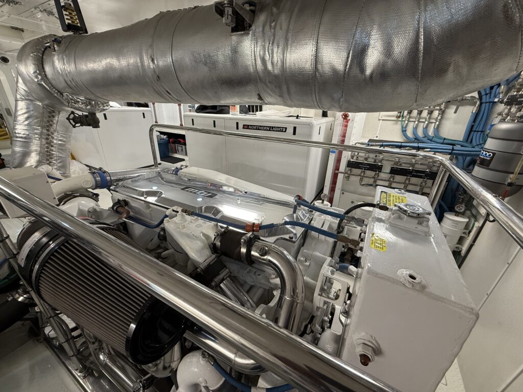 N6416 - AEGEAN MIST - engine room showing main MAN diesel engine with silver exhaust wrap, blue hoses, and Northern Lights generator visible in background