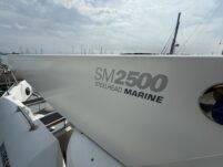 N6416 - AEGEAN MIST - starboard bow profile of yacht showing SM2500 Steelhead Marine tender stored on davits with marina masts visible in the background