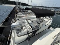 N6416 - AEGEAN MIST - Walker Bay tender with Honda outboard and black bimini top viewed from above on foredeck at marina