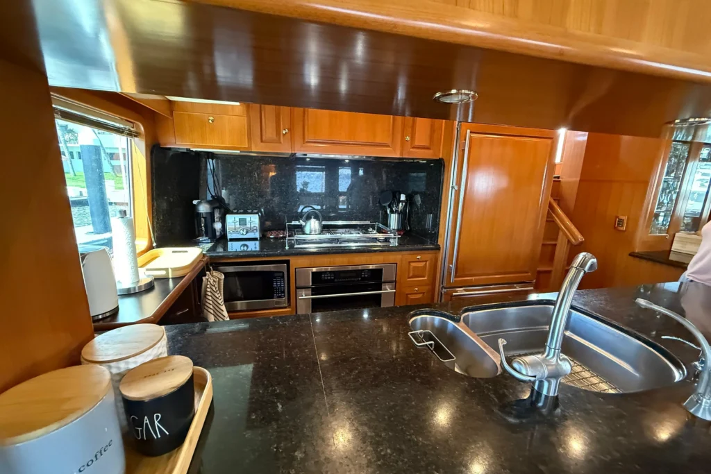 2006 Nordhavn 64 - KARIWA 9 - Luxurious kitchen interior of a 2006 Nordhavn 64 yacht with modern appliances and wooden cabinetry.