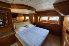 2006 Nordhavn 64 - KARIWA 10 - Luxurious 2006 Nordhavn 64 yacht bedroom with elegant wood finishes and cozy bedding.