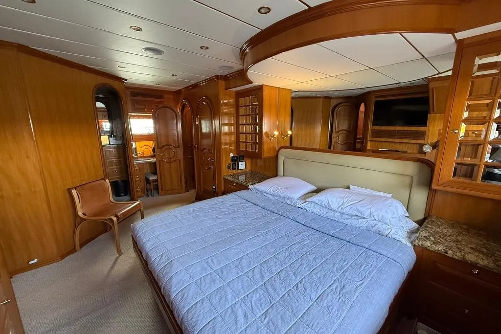 2006 Nordhavn 64 - KARIWA 12 - Luxurious 2006 Nordhavn 64 yacht bedroom with elegant wood paneling and cozy bedding.