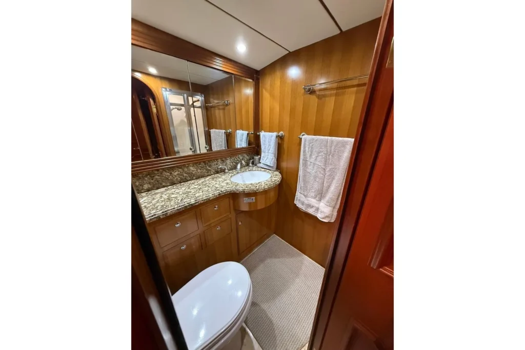 2006 Nordhavn 64 - KARIWA 18 - Luxurious bathroom in 2006 Nordhavn 64 yacht with granite countertop and wooden cabinetry.
