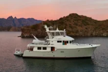 2006 Nordhavn 64 - KARIWA 2 - Nordhavn 64 yacht from 2006 anchored near scenic coastline at sunset.
