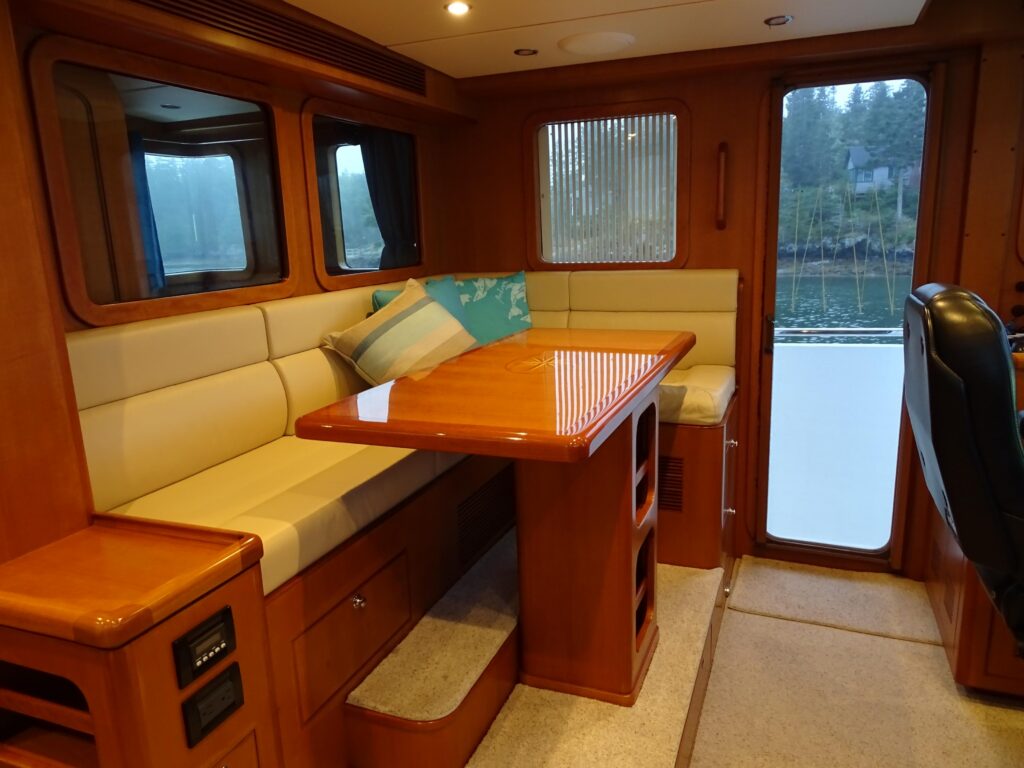 2017 Nordhavn 60 - REDEEMED 26 - Interior of a 2017 Nordhavn 60 with a cozy seating area and wooden table.