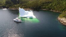 2017 Nordhavn 60 - REDEEMED 3 - A 2017 Nordhavn 60 sails past a large iceberg in a calm bay.