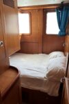 2017 Nordhavn 60 - REDEEMED 30 - Cabin of the 2017 Nordhavn 60 with a cozy bed and wooden walls.