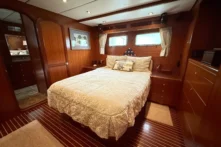 2008 Nordhavn 55 - ADVENTURE 11 - Luxurious 2008 Nordhavn 55 yacht bedroom with elegant wood paneling and cozy bedding.